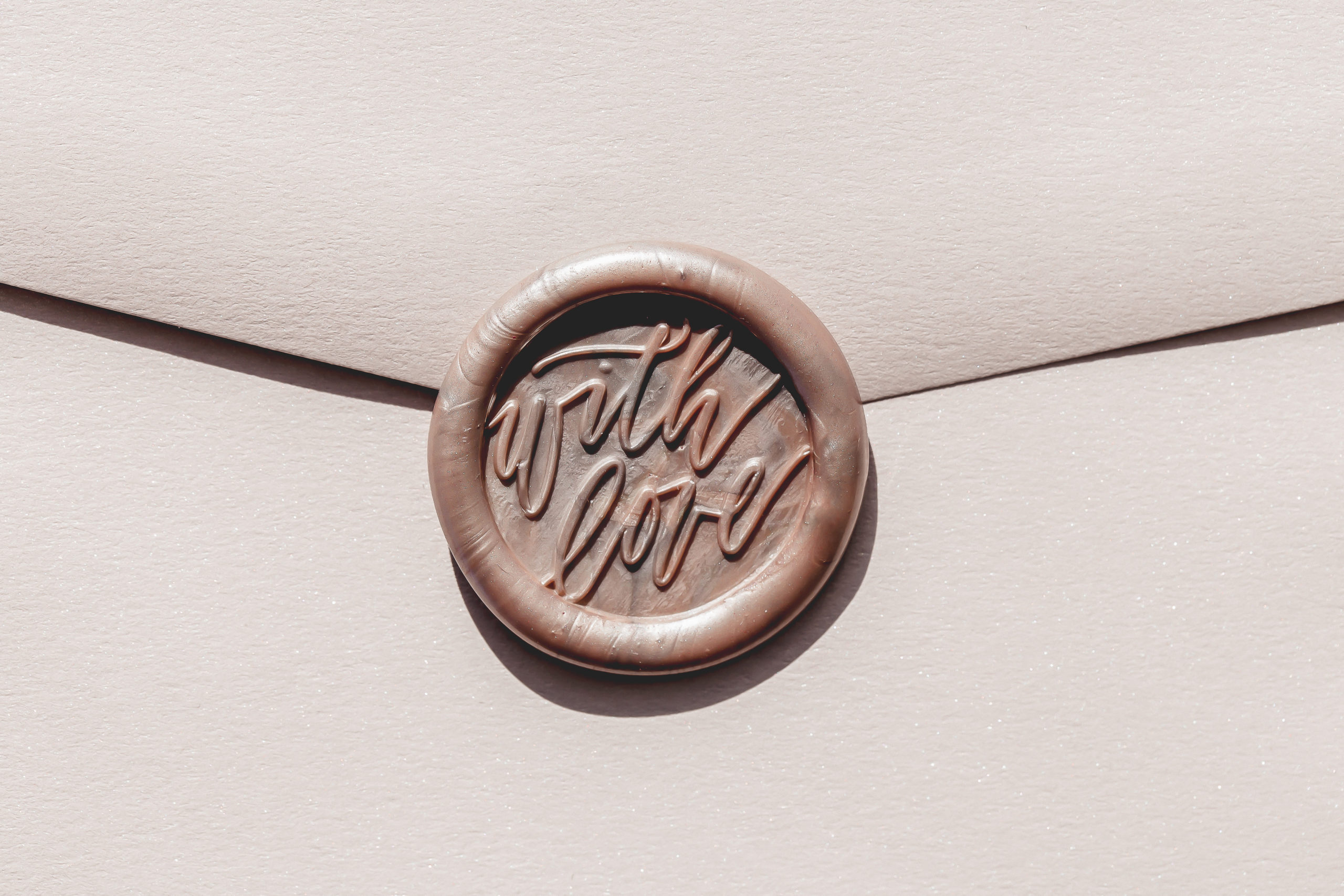 envelope with wax seal that says "with love"