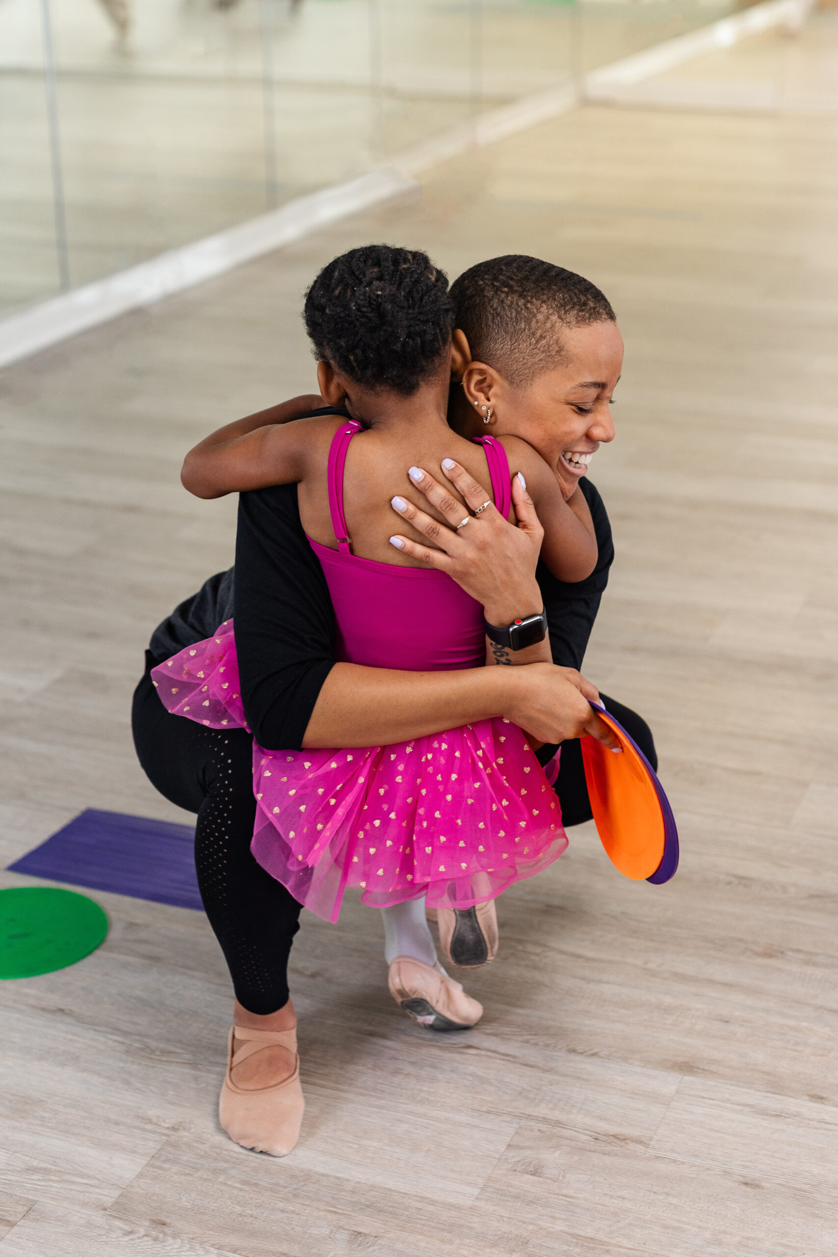 Ms Joie receives a grateful hug from a young ballet student