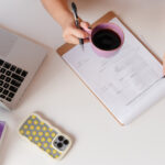 an overhead shot of a desktop featuring crystals, headphones and a cute phone case