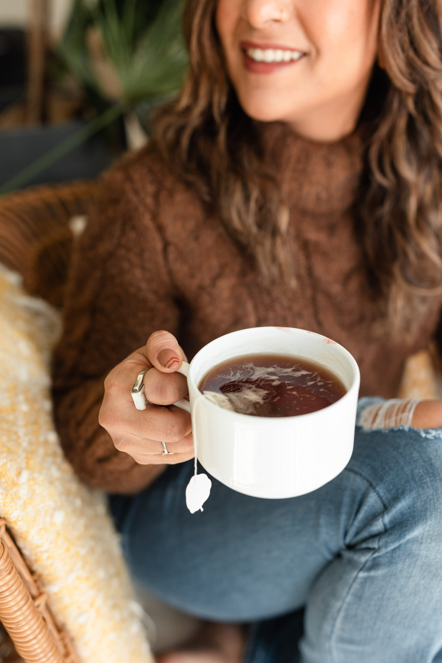 a latina woman smiles holding a mug of hot tea