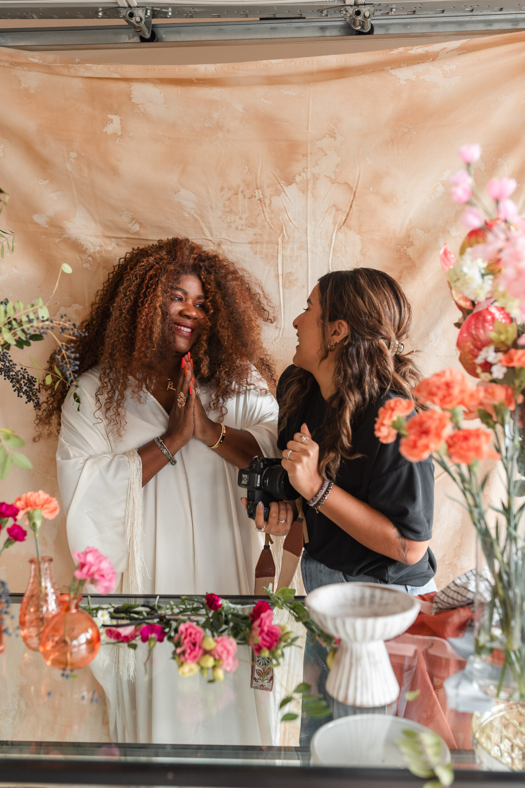 a latina photographer shows her wedding florist client the back of camera at her branding session