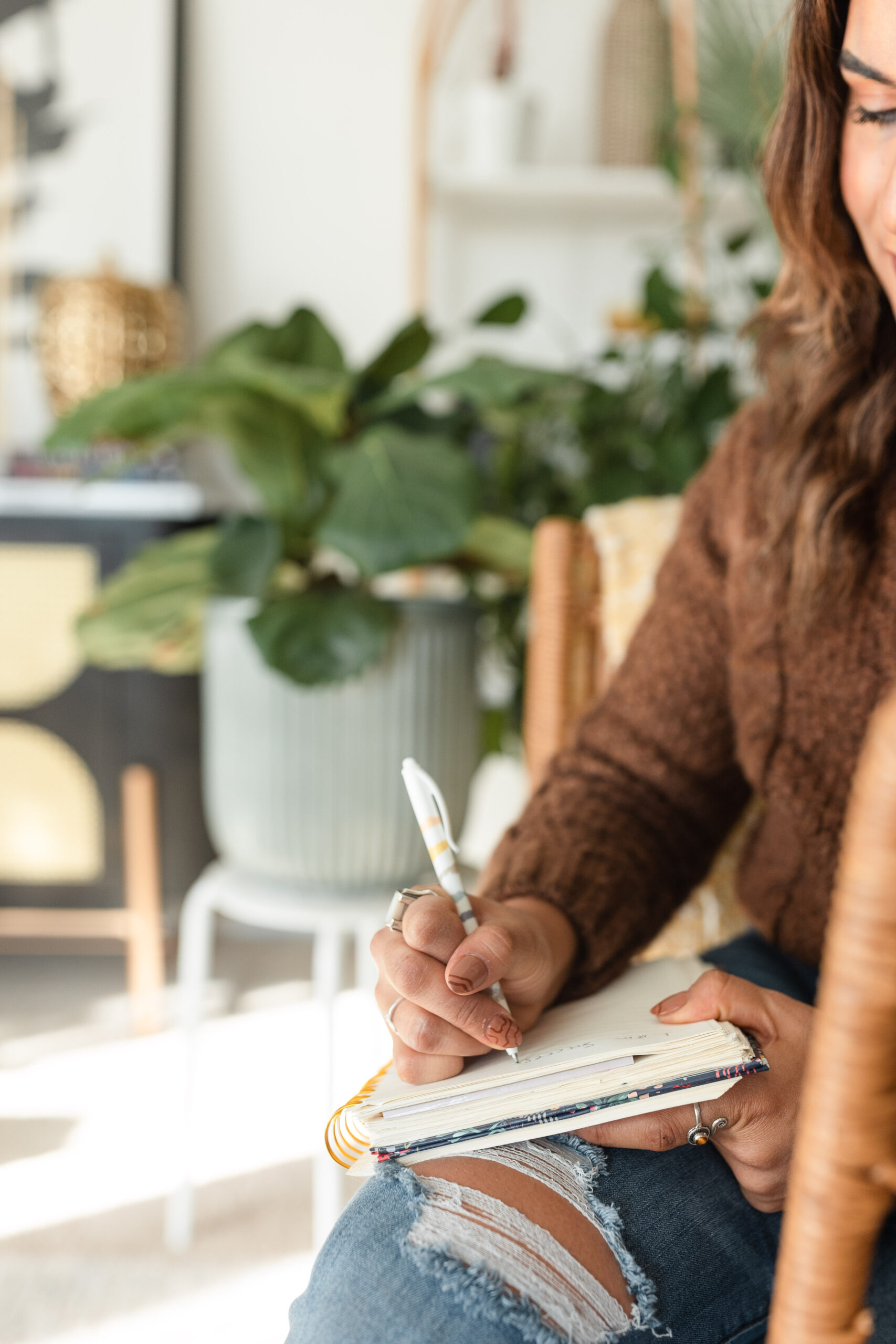 latina photographer writes in a journal, surrounded by plants