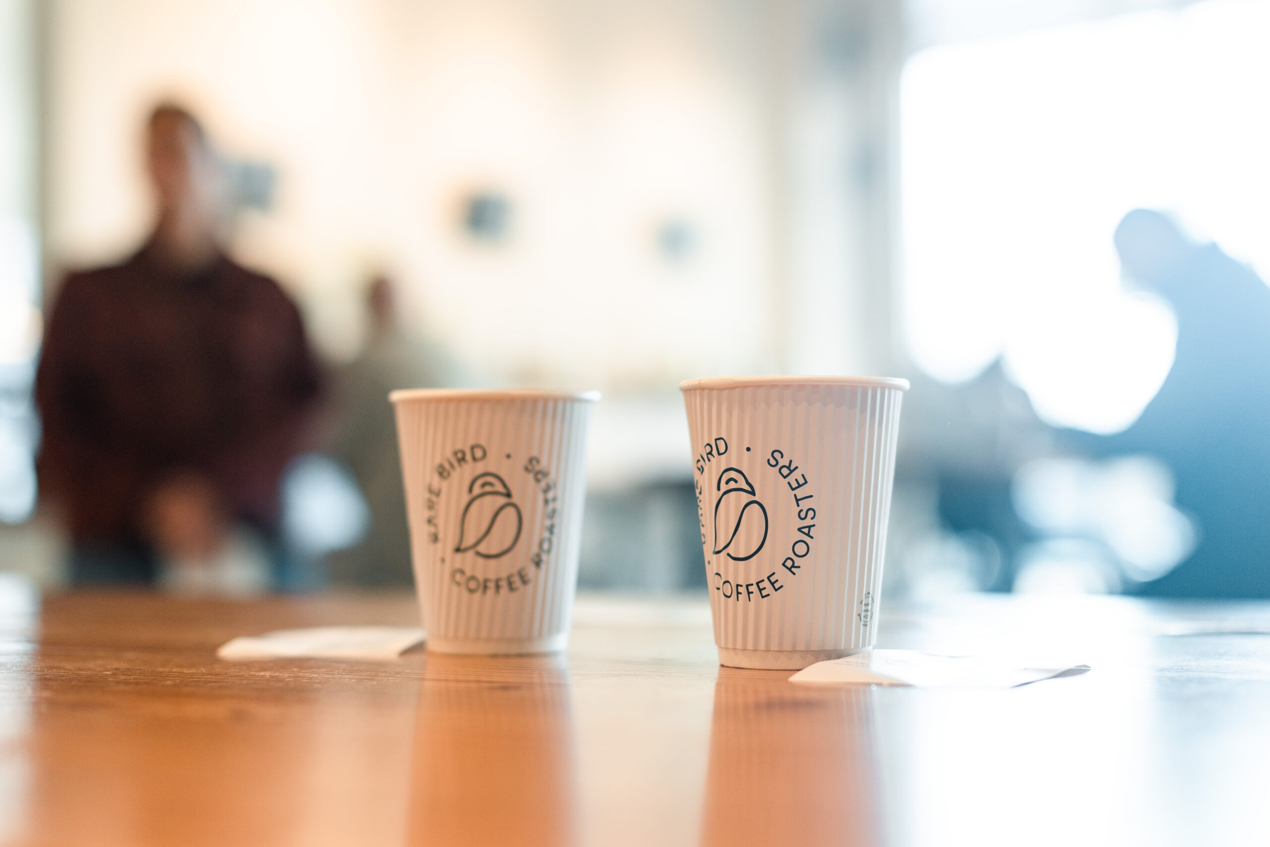 Two to-go cups of coffee on the counter at Rare Bird Coffee Roasters in Falls Church City, Virginia