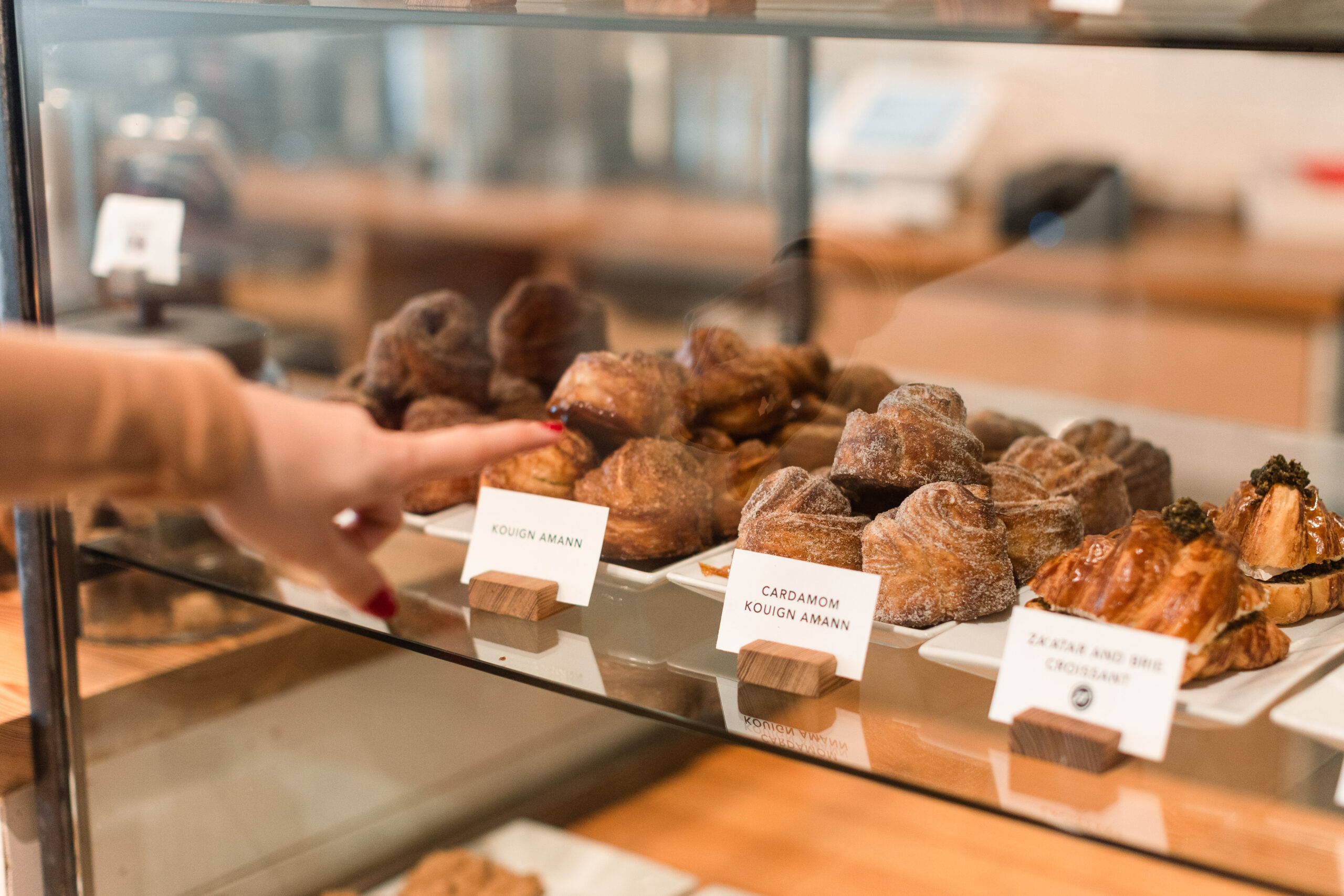 A customer points at the pastry options in the case