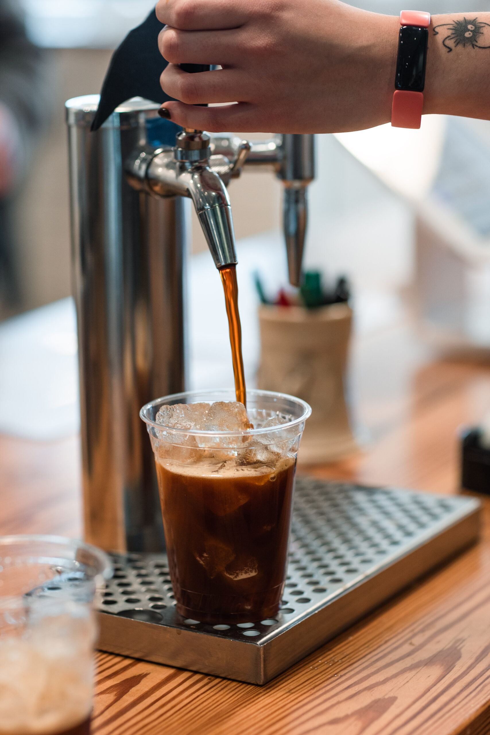 A barista pour a nitro cold brew for a customer